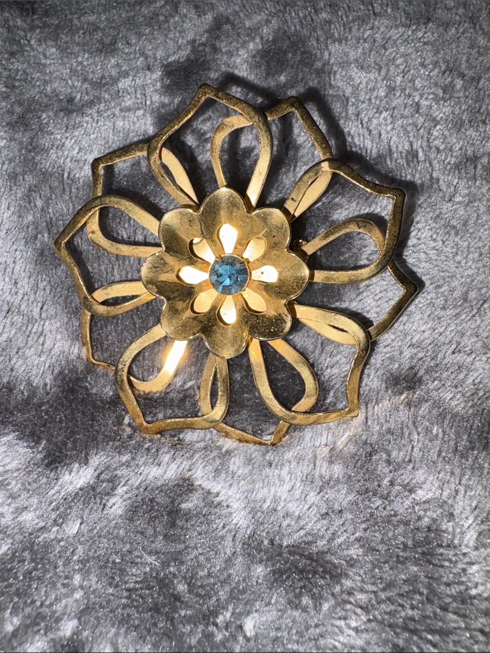 Goldtone Open filigree Floral Brooch with Blue Prong Set Deep Blue Center
